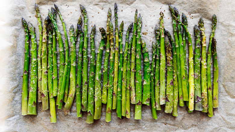 Asparagus stalks seasoned on parchment paper