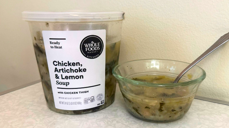 A tub and small glass bowl filled with Chicken, Artichoke & Lemon Soup