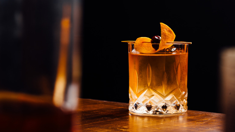 a classic old fashioned cocktail with an orange and cherry garnish