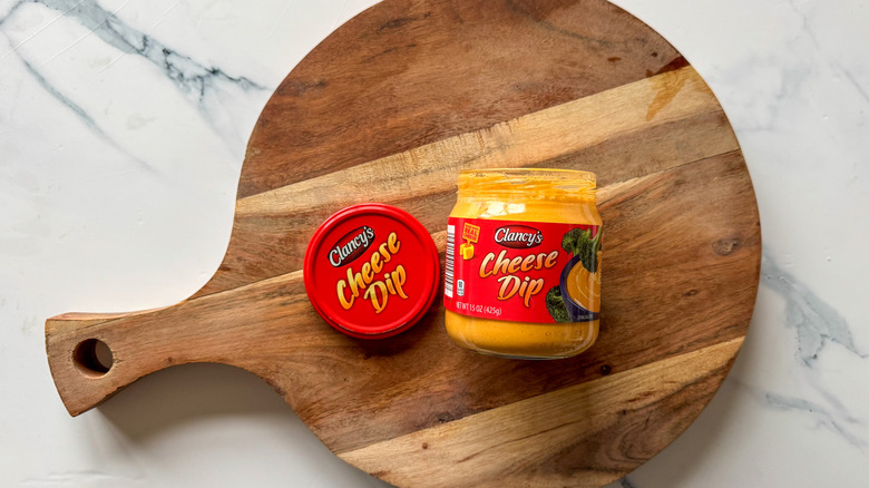Jar of Clancy's Cheese Dip on round, wooden cutting board