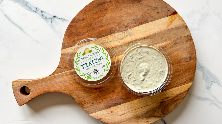 Spinach Parmesan Tzatziki on round, wooden cutting board