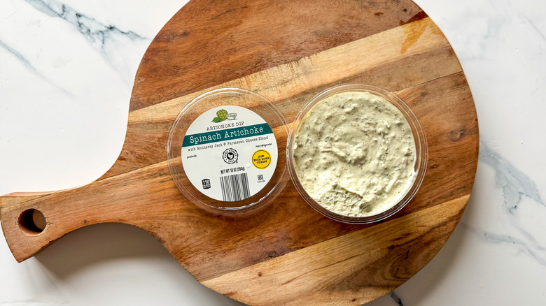 Spinach Artichoke Dip on round, wooden cutting board