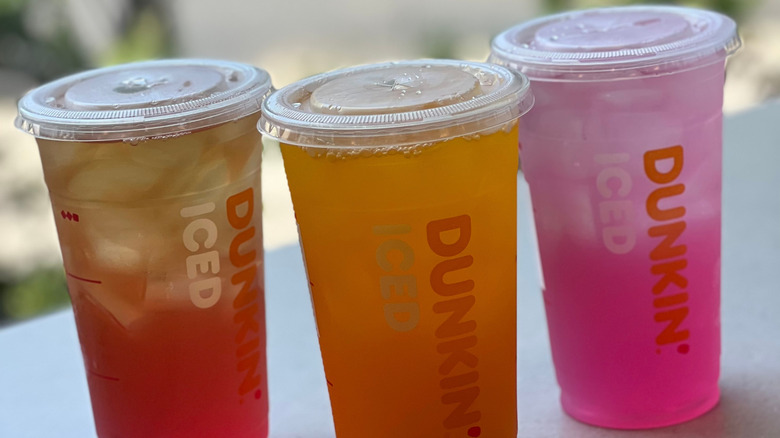 Various Dunkin' Refreshers sitting on outdoor ledge