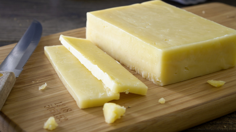 block of cheese on cutting board