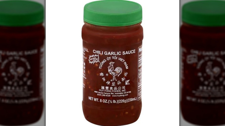 Huy Fong Chili Garlic Sauce in a clear jar with a green lid.