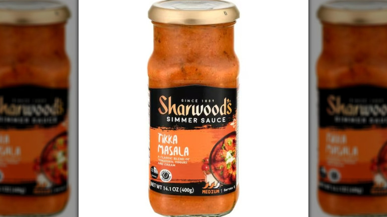 Simmer sauce in a tall glass jar with a gold lid.