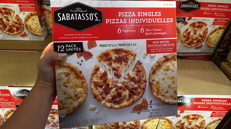 Hand holding individual pizza box at Costco