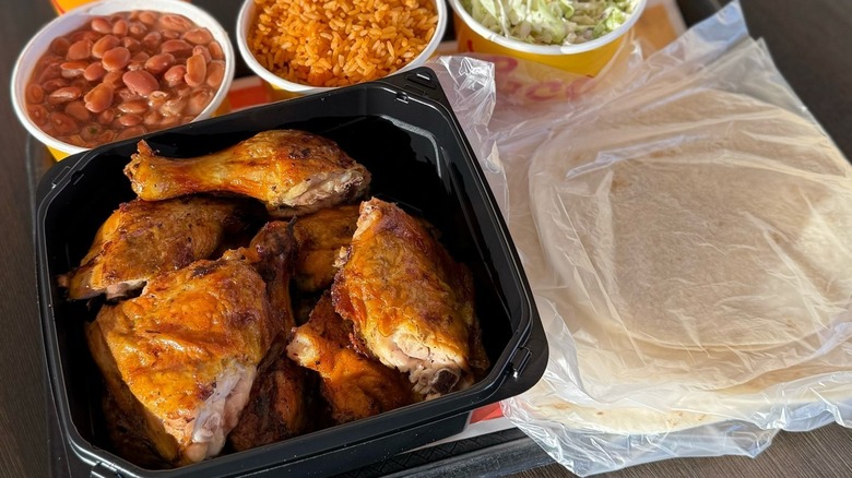 A takeaway container of chicken with beans, rice, coleslaw, and tortillas from El Pollo Loco