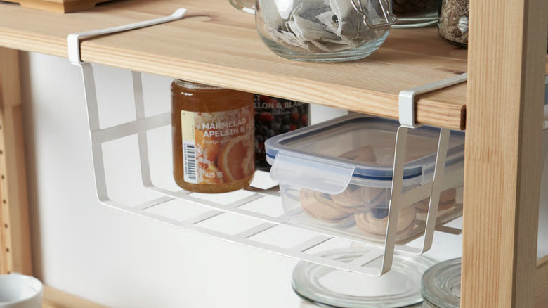 PÅLYCKE hanging off a shelf organizing various jams and cookies