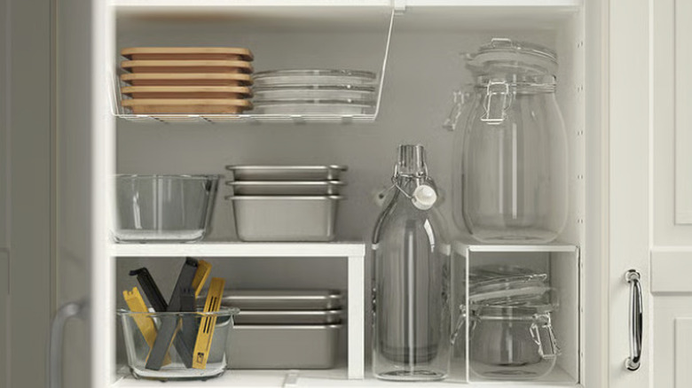 Multiple VARIERA shelving units sitting in a cabinet organizing various kitchen materials