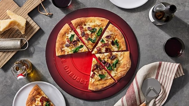 Le Creuset pizza stone with pizza and toppings