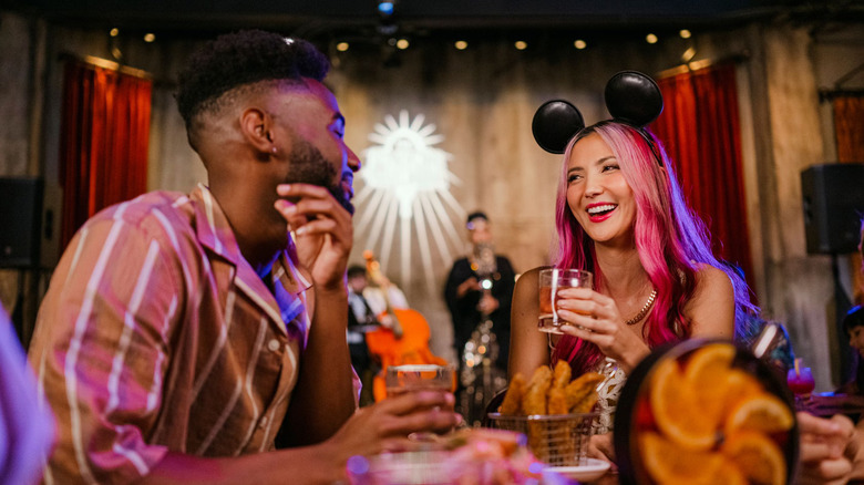 person with Mickey ears holding bourbon