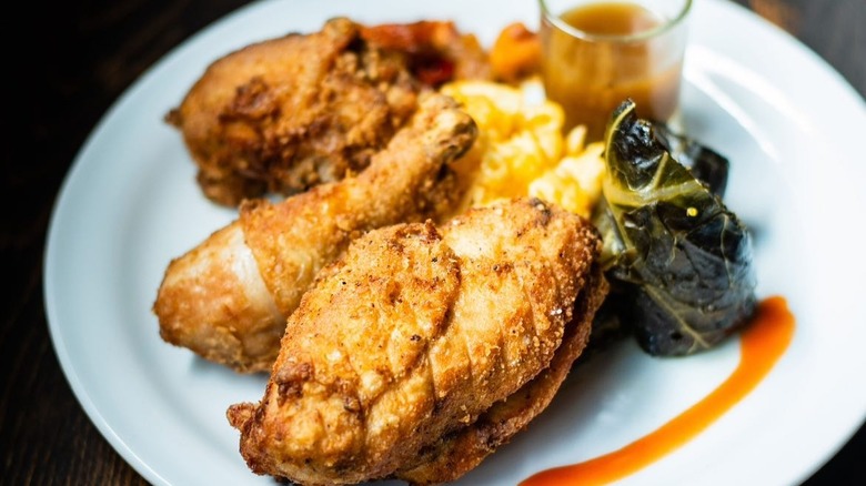 Fried chicken and soul food sides elegantly arranged on a white plate