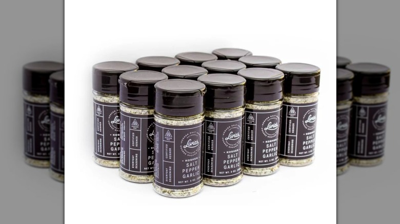 12 shakers of Livia's Salt Pepper Garlic on a white background