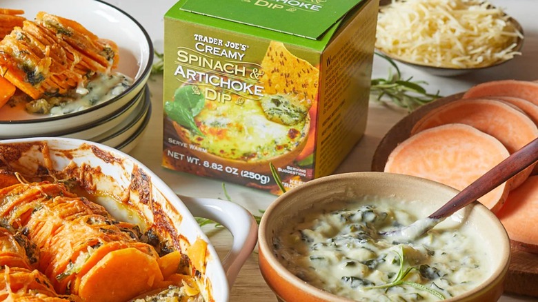 Package and bowl of Trader Joe's Creamy Spinach & Artichoke Dip surrounded by other dishes