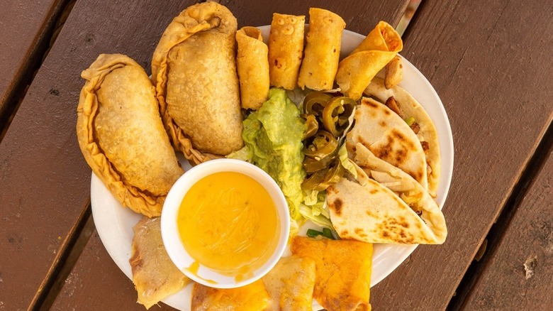 Platter of Tex-Mex bites and cup of yellow queso