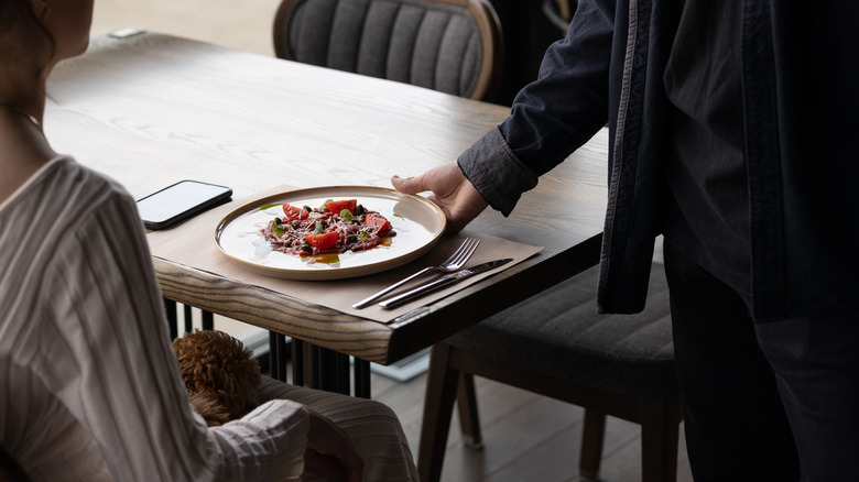 Person being served a plate of food in a restaurant