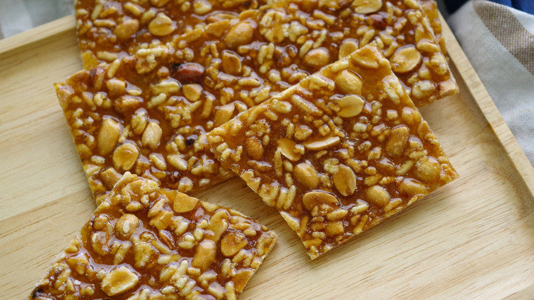 Squares of peanut brittle on a wooden background