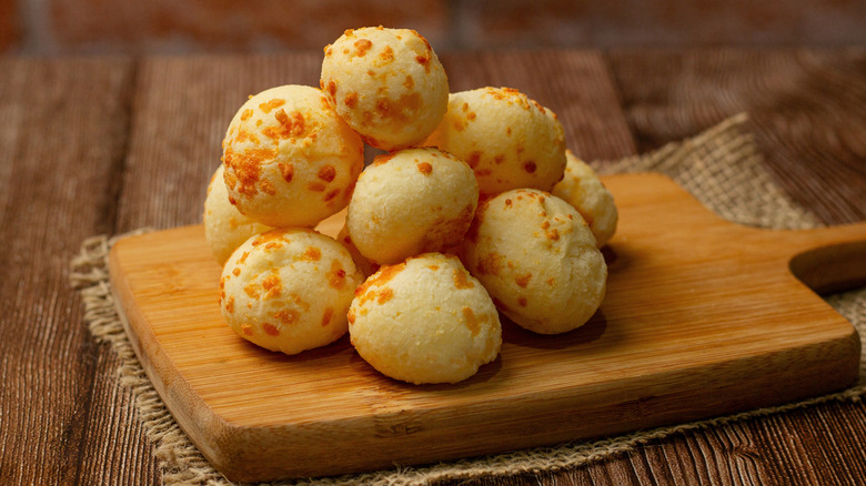Balls of pão de queijo on a wooden serving board