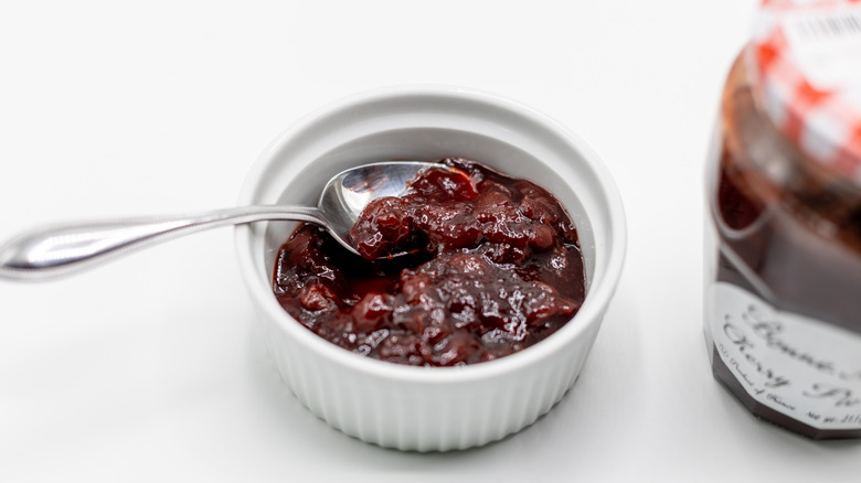 Spoon in a jar of pie filling with jar next to it