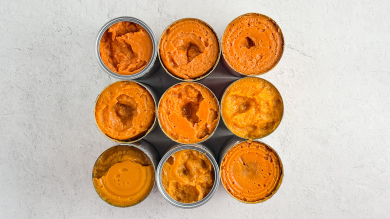 An overhead view of nine cans of pumpkin purée