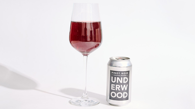 Can of Underwood Pinot Noir next to a filled wine glass
