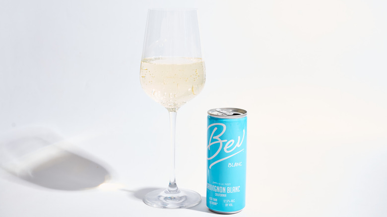 Can of Bev Blanc Sauvignon Blanc next to a filled wine glass