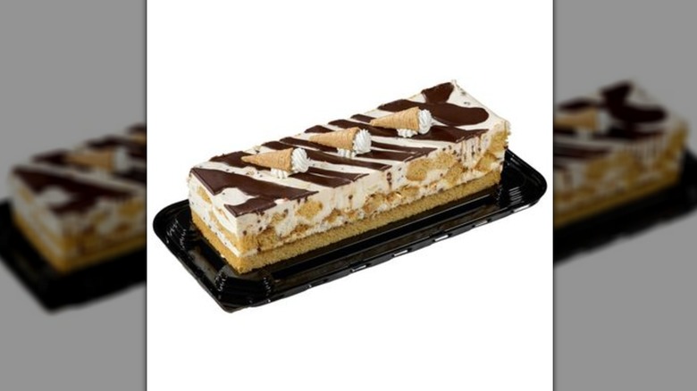 Rectangular layered cake topped with whipped cream filled mini waffle cones