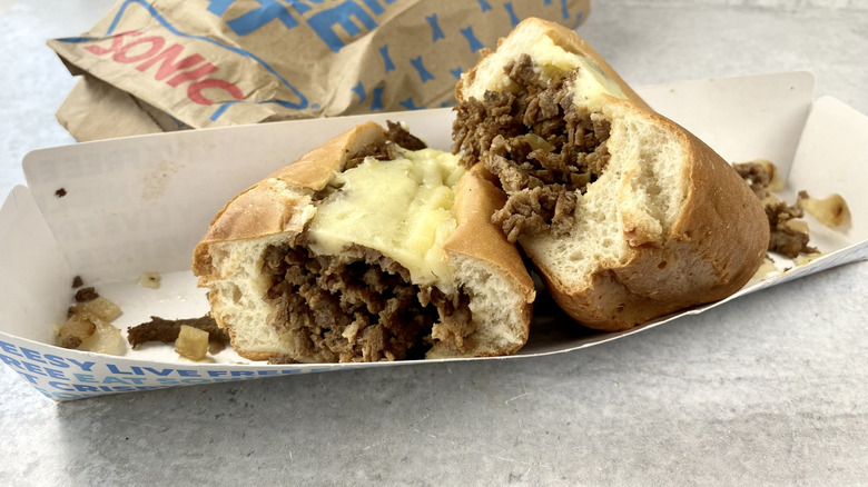 Sonic's Philly Cheesesteak cut in half in the take-out container.