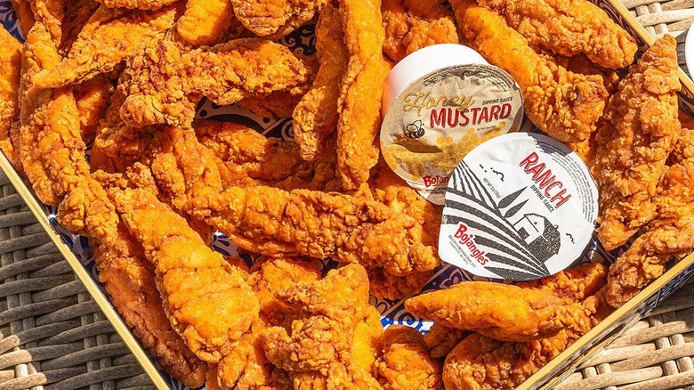 A takeout box of chicken tenders with honey mustard and ranch dressing from Bojangles