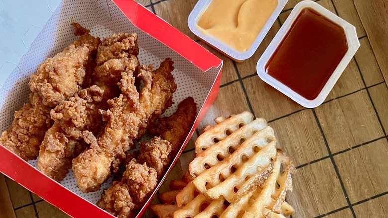 A box of Chicken Strips with waffle fries and sauces from Chick-fil-A