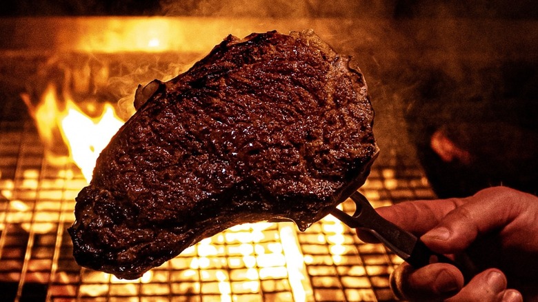 Steak being cooked over hot charcoals