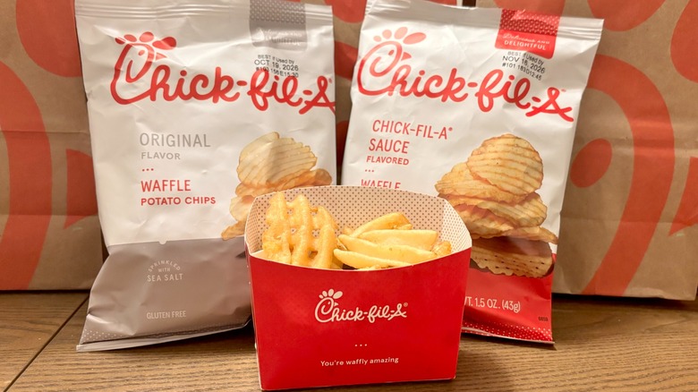 Chick-fil-A's Waffle Fries next to two bags of the chain's Waffle Potato Chips