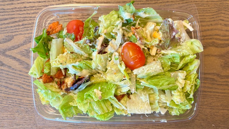 Top-down view of Chick-fil-A Side Salad with lettuce mix, grape tomatoes, and lots of creamy dressing