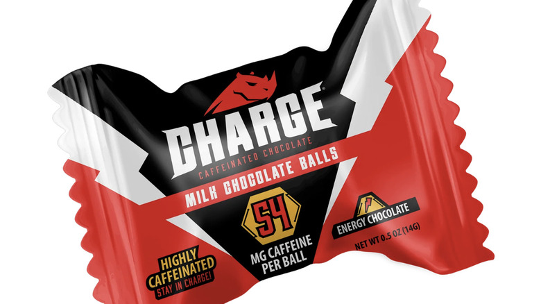 a close up picture of a wrapped charge milk chocolate ball on a white background