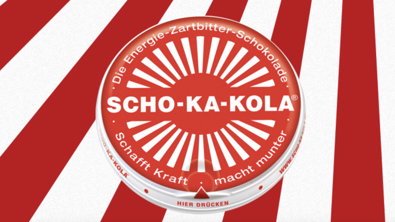 a Scho-Ka-Kola disc on a red and white striped background