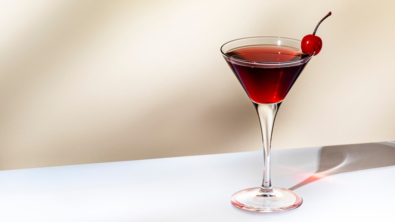 Amaretto Cosmopolitan with cherry garnish on a white background