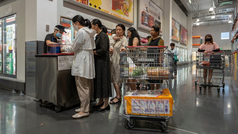 shoppers waiting in line at a sample station in Costco