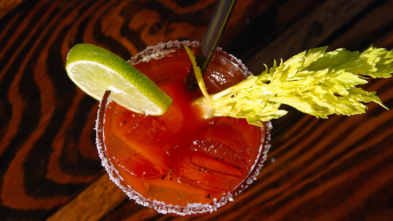 A bloody mary in a glass with lime and celery