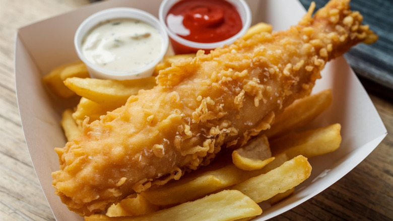 Fried battered fish and chips with ketchup and tartar sauce