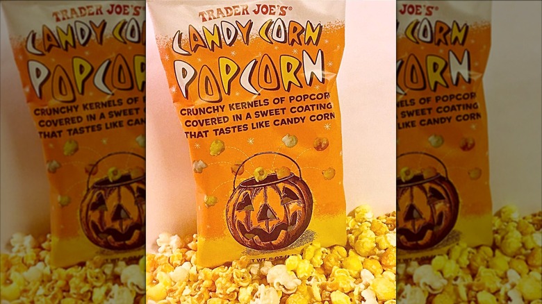 A bag of Candy Corn Popcorn with handfuls of popcorn in front of it