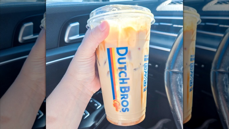 A person holding a Dutch Bros iced Banana Bread latte