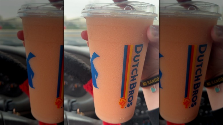 A person holding a blended Pink Flamingo Dutch Bros drink