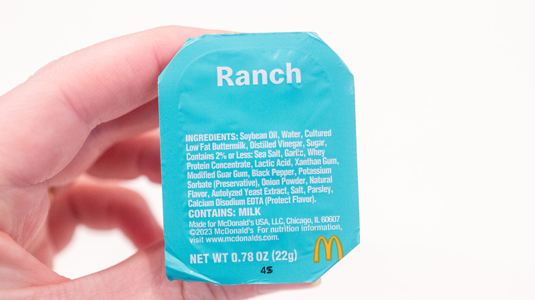 A hand holds a container of McDonald's Ranch