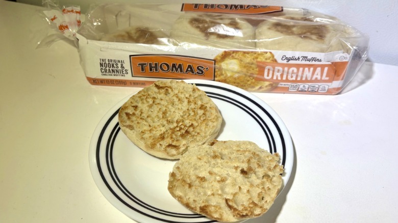 A package of Thomas' Original English Muffins behind a plate with a toasted muffin on it
