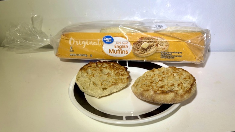 A package of Great Value Original Fork Split English Muffins leaning on a plate with a toasted muffin on it