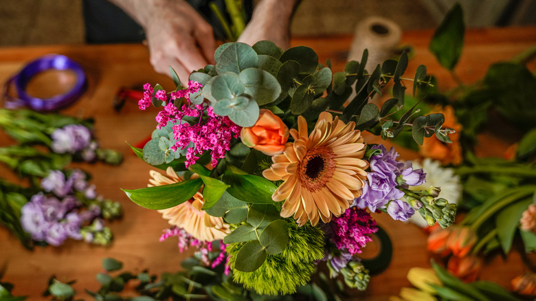 A florist putting together bouquet of flowers
