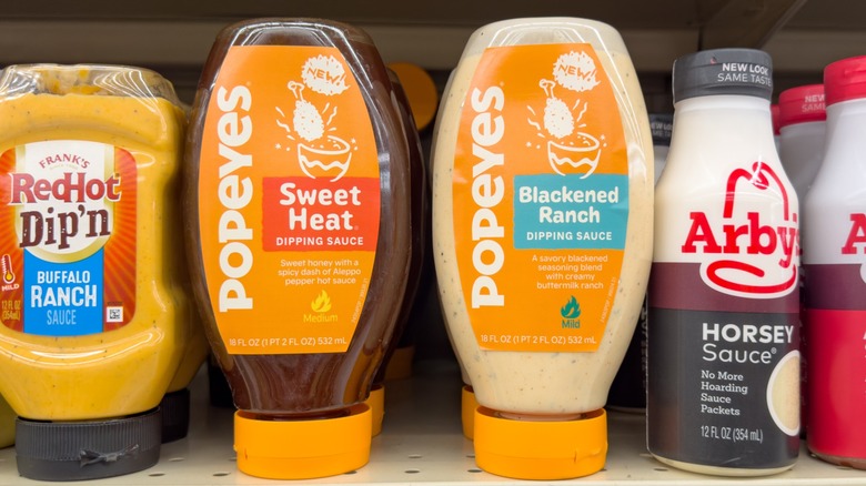 two Popeyes dipping sauces on a grocery store shelf