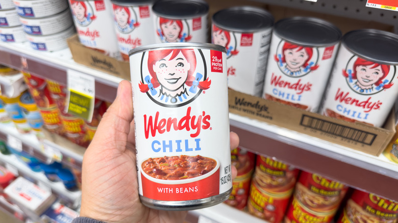 hand holding can of Wendy's Chili With Beans in a grocery store