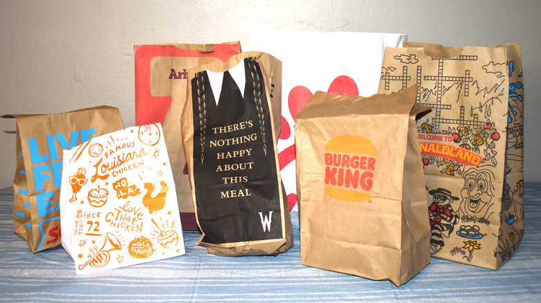 assortment of fast food to-go bags on a table